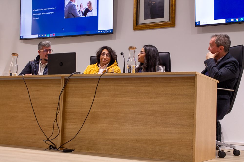 Equipo de Jaque Digital participando en una charla universitaria sobre emprendimiento y transformación digital, sentados en una mesa redonda con micrófonos.